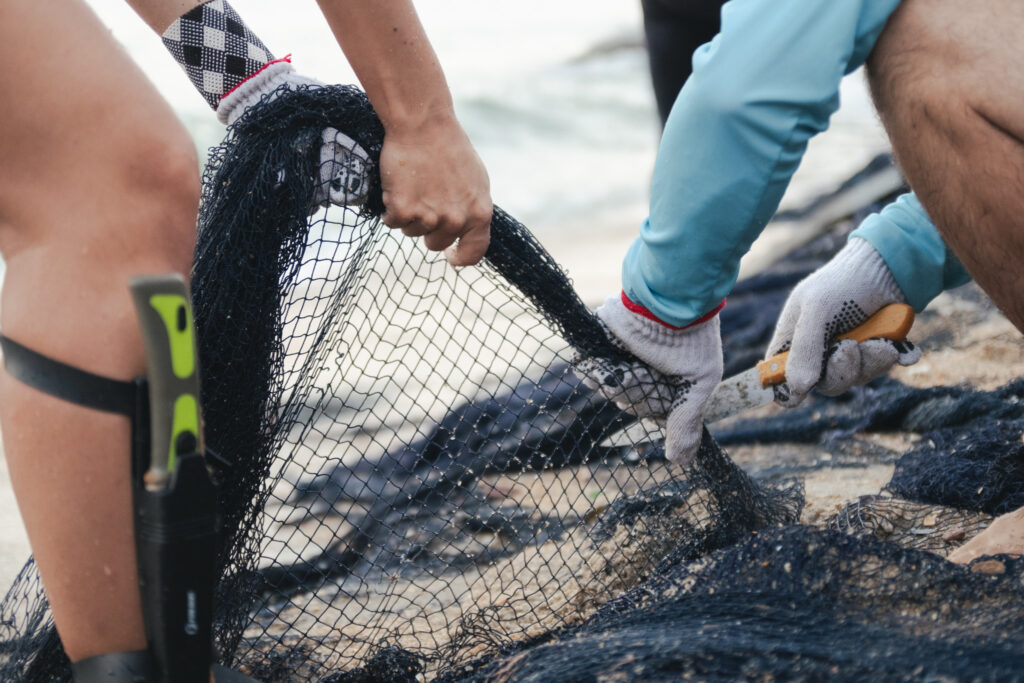 Voluntários retirando rede fantasma do mar